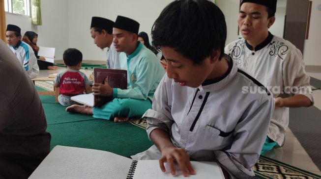 Para santri tunanetra di Pesantren Raudlatul Makfufin, Kota Tangerang Selatan (Tangsel), tengah membaca Al Quran dengan mushaf braile. [Suara.com/Wivy Hikmatullah]