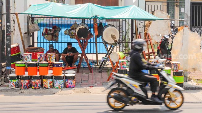 Penjual bedug menunggu pembeli di Jalan KH Mas Mansyur, Tanah Abang, Jakarta Pusat, Jumat (15/4/2022). [Suara.com/Alfian Winanto]