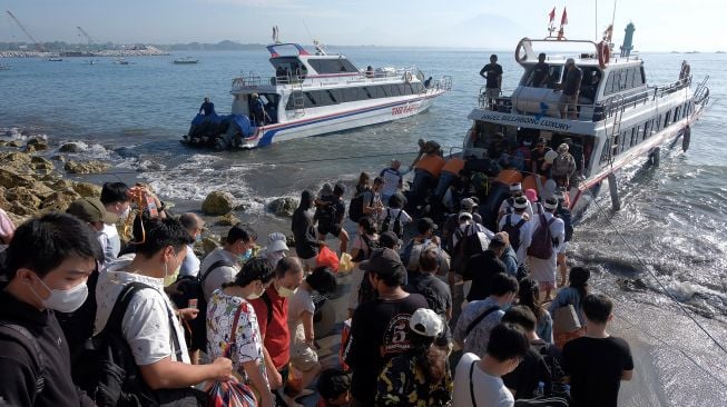 Wisatawan mengantre saat naik ke kapal cepat untuk menyeberang menuju Pulau Nusa Penida saat liburan panjang berkenaan dengan Hari Paskah di Pelabuhan Sanur, Denpasar, Bali, Jumat (15/4/2022). ANTARA FOTO/Nyoman Hendra Wibowo