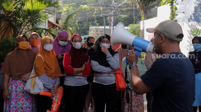 Sejumlah warga mengantre untuk mendapatkan sayuran dan pakaian bekas layak pakai yang dijajakan secara gratis di Jalan Jati Padang VI RT 002 RW 004, Pasar Minggu, Jakarta, Minggu (17/4/2022). [Suara.com/Angga Budhiyanto]