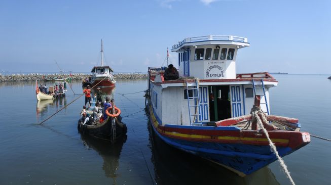 Warga kepulauan bersiap naik ke perahu motor untuk mudik lebih awal di Pelabuhan Kalbut, Situbondo, Jawa Timur, Sabtu (16/4/2022). [ANTARA FOTO/Seno/rwa]