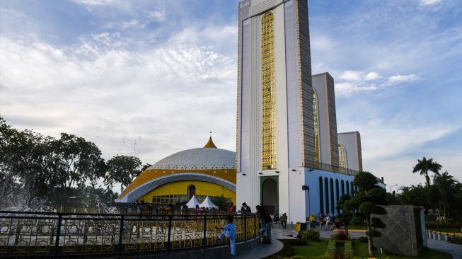 Sejumlah warga berada di halaman Masjid Agung Sultan Thaf Sinar Basarsyah, Deli Serdang, Sumatera Utara, Jumat (15/4/2022). [ANTARA FOTO/Fransisco Carolio/Lmo/foc]
