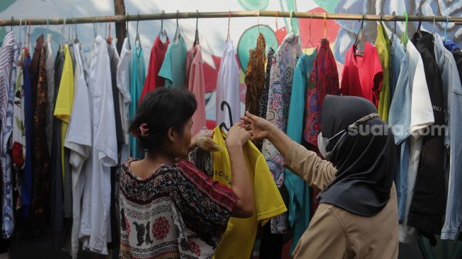 Warga memilih pakaian bekas layak pakai yang dijajakan secara gratis di Jalan Jati Padang VI RT 002 RW 004, Pasar Minggu, Jakarta, Minggu (17/4/2022). [Suara.com/Angga Budhiyanto]