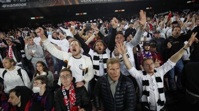 Pendukung Eintracht Frankfurt merayakan kemenangan setelah tim tersebut mengalahkan Barcelona pada leg kedua perempat final Liga Europa di Camp Nou, Barcelona, 14 April 2022. REUTERS/Albert Gea (REUTERS/ALBERT GEA)