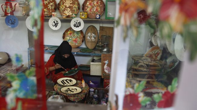 Perajin menyelesaikan lukisan kaligrafi Arab pada piring keramik di rumah produksi Fairus Art, Desa Plumbon, Sukoharjo, Jawa Tengah, Sabtu (16/4/2021). [ANTARAFOTO/Maulana Surya/rwa]
