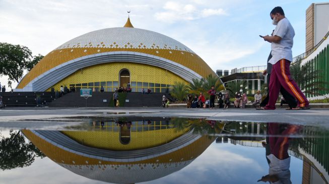 Sejumlah warga berada di halaman Masjid Agung Sultan Thaf Sinar Basarsyah, Deli Serdang, Sumatera Utara, Jumat (15/4/2022). [ANTARA FOTO/Fransisco Carolio/Lmo/foc]
