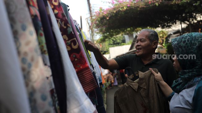 Warga memilih pakaian bekas layak pakai yang dijajakan secara gratis di Jalan Jati Padang VI RT 002 RW 004, Pasar Minggu, Jakarta, Minggu (17/4/2022). [Suara.com/Angga Budhiyanto]