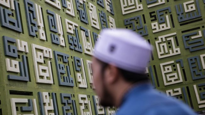 Seorang warga muslim berjalan di depan Masjid Asmaul Husna, Kelapa Dua, Kabupaten Tangerang, Banten, Sabtu (16/4/2022). ANTARA FOTO/Fauzan
