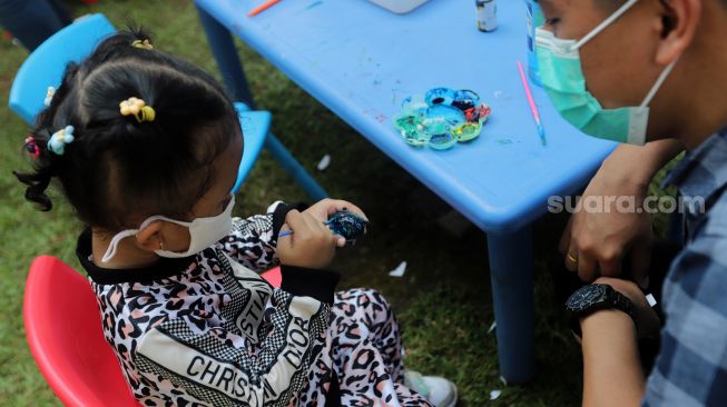 Peserta mengikuti lomba melukis telur di Lapangan Banteng, Jakarta, Minggu (17/4/2022). [Suara.com/Angga Budhiyanto]