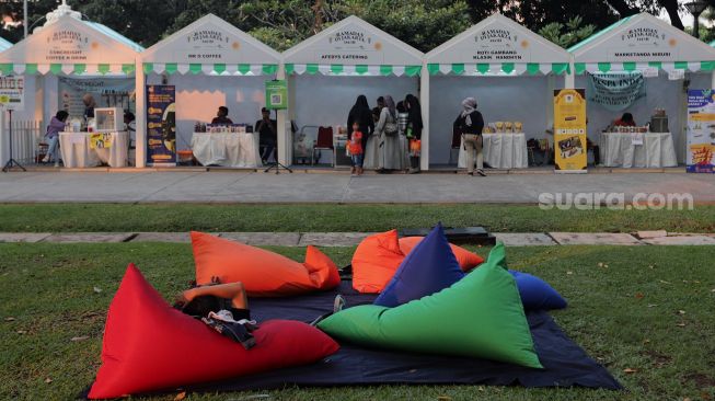 Warga bersantai di Lapangan Banteng, Jakarta, Minggu (17/4/2022). [Suara.com/Angga Budhiyanto]