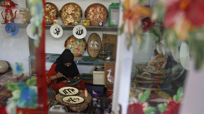 Perajin menyelesaikan lukisan kaligrafi Arab pada piring keramik di rumah produksi Fairus Art, Desa Plumbon, Sukoharjo, Jawa Tengah, Sabtu (16/4/2021). ANTARAFOTO/Maulana Surya