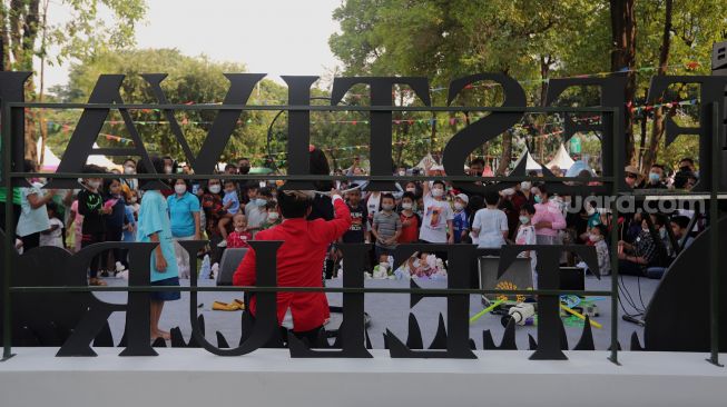 Pengunjung menikmati suasana Festival Telur 2022 di Lapangan Banteng, Jakarta, Minggu (17/4/2022). [Suara.com/Angga Budhiyanto]