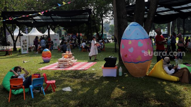 Pengunjung menikmati suasana Festival Telur 2022 di Lapangan Banteng, Jakarta, Minggu (17/4/2022). [Suara.com/Angga Budhiyanto]