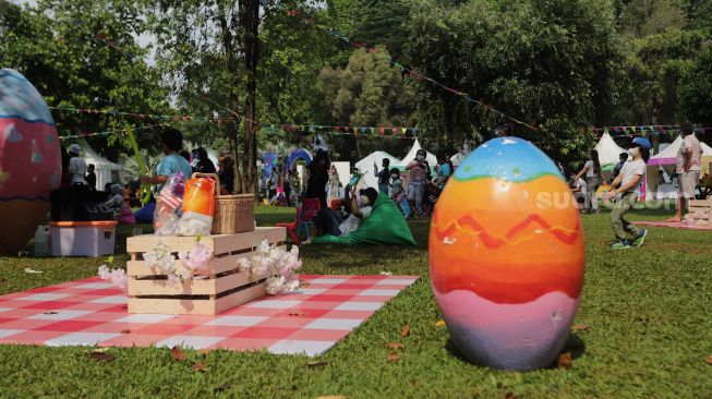 Pengunjung menikmati suasana Festival Telur 2022 di Lapangan Banteng, Jakarta, Minggu (17/4/2022). [Suara.com/Angga Budhiyanto]