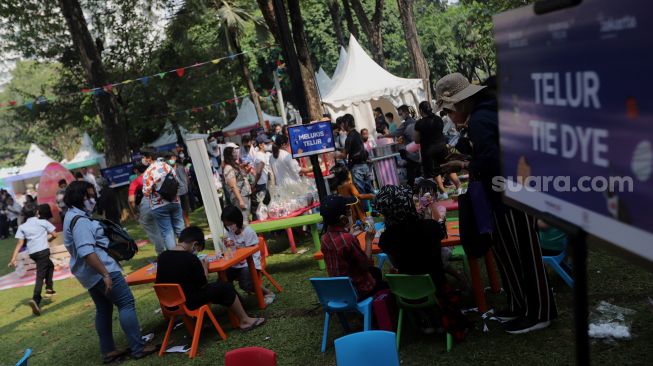 Peserta mengikuti lomba melukis telur di Lapangan Banteng, Jakarta, Minggu (17/4/2022). [Suara.com/Angga Budhiyanto]