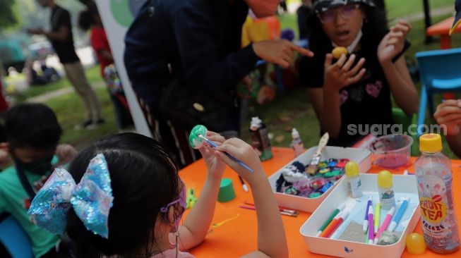 Peserta mengikuti lomba melukis telur di Lapangan Banteng, Jakarta, Minggu (17/4/2022). [Suara.com/Angga Budhiyanto]