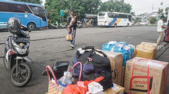 Calon pemudik menunggu di Kampung Rambutan, Jakarta Timur, Senin (18/4/2022). [Suara.com/Alfian Winanto]