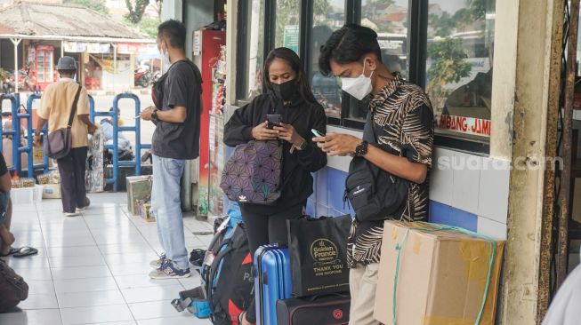 Calon pemudik menunggu di Kampung Rambutan, Jakarta Timur, Senin (18/4/2022). [Suara.com/Alfian Winanto]