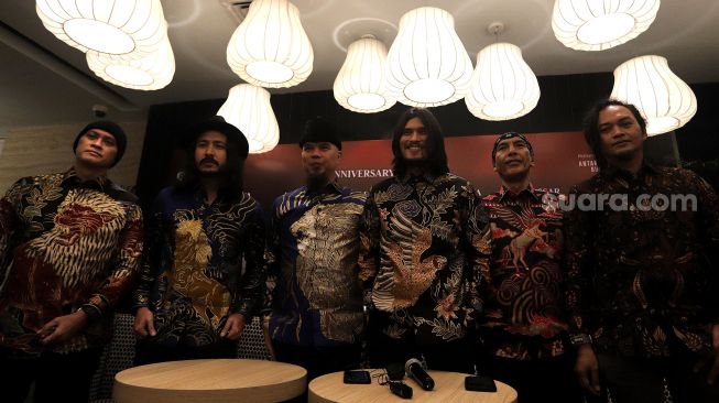 Para personel grup musik Dewa 19 berfoto bersama dengan penyanyi Marcello Tahitoe alias Ello (kedua kiri) dan Virzha (ketiga kanan) usai acara "Anniversary Tour 30 Years Of Dewa 19" di Jakarta, Selasa (19/4/2022). [Suara.com/Angga Budhiyanto]