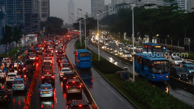 Sejumlah kendaraan terjebak kemacetan di kawasan Sudirman, Jakarta Pusat, Selasa (19/4/2022). [Suara.com/Alfian Winanto]
