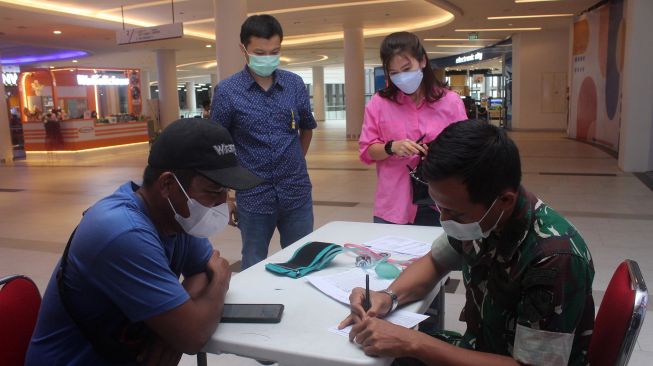 Vaksinator dari TNI AU melakukan pendataan kepada tiga pengunjung yang akan divaksin saat vaksinasi di Gaia Mall di Kabupaten Kubu Raya, Kalimantan Barat, Selasa (19/4/2022).  ANTARA FOTO/Jessica Helena Wuysang