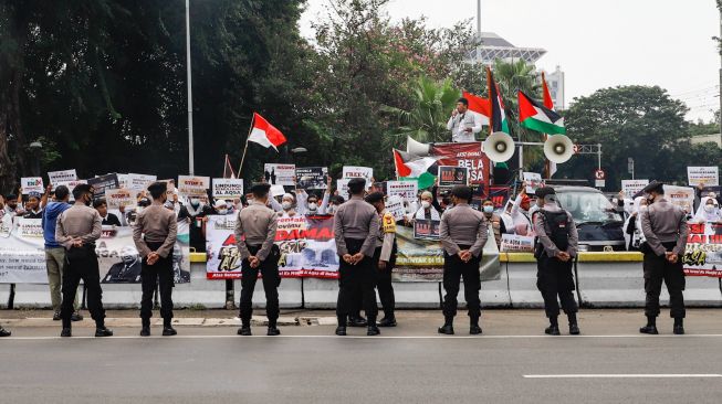 Sejumlah massa dari lembaga kemanusiaan Aqsa Working Group (AWG) saat menggelar aksi Bela Al-Aqsa di depan Kedutaan Besar Amerika di Jalan Medan Merdeka Selatan, Jakarta Pusat, Rabu (20/4/2022). [Suara.com/Alfian Winanto]