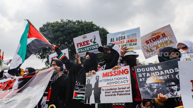 Sejumlah massa dari lembaga kemanusiaan Aqsa Working Group (AWG) saat menggelar aksi Bela Al-Aqsa di depan Kedutaan Besar Amerika di Jalan Medan Merdeka Selatan, Jakarta Pusat, Rabu (20/4/2022). [Suara.com/Alfian Winanto]