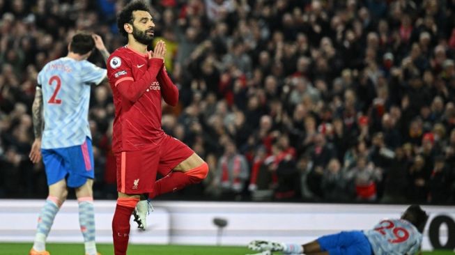 Penyerang sayap Liverpool, Mohamed Salah (tengah) melakukan selebrasi usai mencetak gol ke gawang Manchester United pada laga Liga Inggris di Anfield, Rabu (20/4/2022) pagi WIB. [Oli Scarff / AFP]