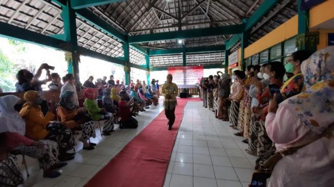  Sejumlah warga masyarakat menyaksikan fashion show buruh gendong dalam rangka menyambut Hari Kartini, di Pasar Beringharjo, Kota Jogja, Rabu (20/4/2022). [Muhammad Ilham Baktora / SuaraJogja.id]