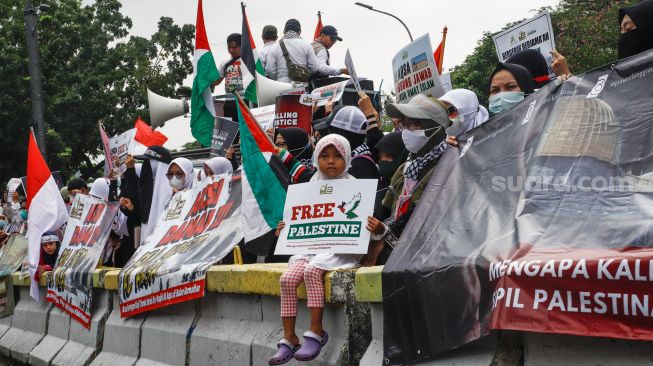 Sejumlah anak-anak ikut berpartisipasi dalam aksi Bela Al-Aqsa di depan Kedutaan Besar Amerika di Jalan Medan Merdeka Selatan, Jakarta Pusat, Rabu (20/4/2022). [Suara.com/Alfian Winanto]