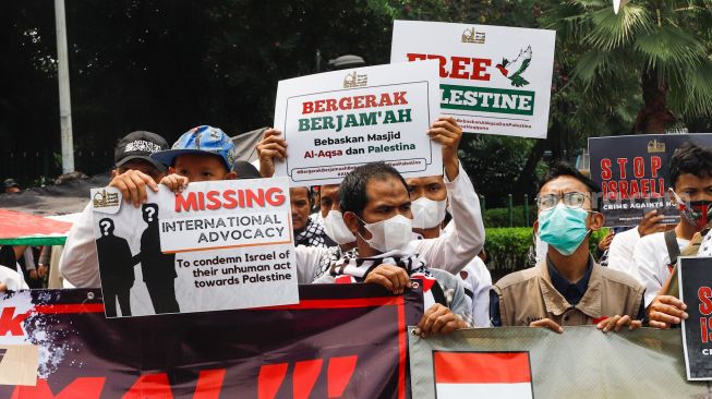 Sejumlah massa dari lembaga kemanusiaan Aqsa Working Group (AWG) saat menggelar aksi Bela Al-Aqsa di depan Kedutaan Besar Amerika di Jalan Medan Merdeka Selatan, Jakarta Pusat, Rabu (20/4/2022). [Suara.com/Alfian Winanto]