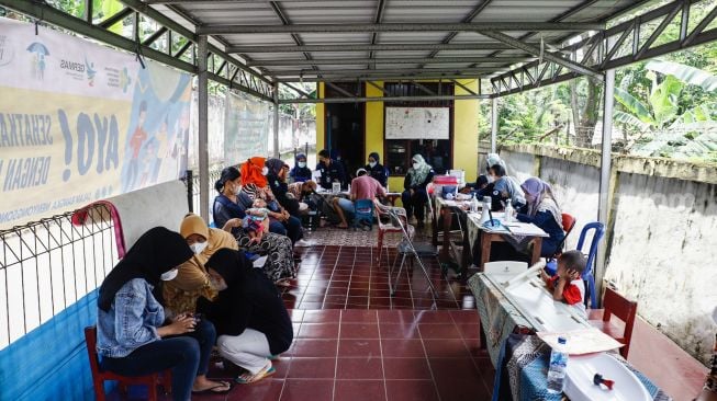 Warga menjalani vaksinasi Covid-19 dosis ketiga atau vaksin booster di Lubang Buaya, Jakarta Timur, Rabu (20/4/2022). [Suara.com/Alfian Winanto]