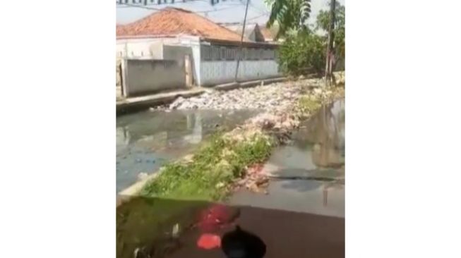 Miris! Kondisi Sungai Penuh Tumpukan Sampah Ini Membuat Jalan hingga Tergenang Air