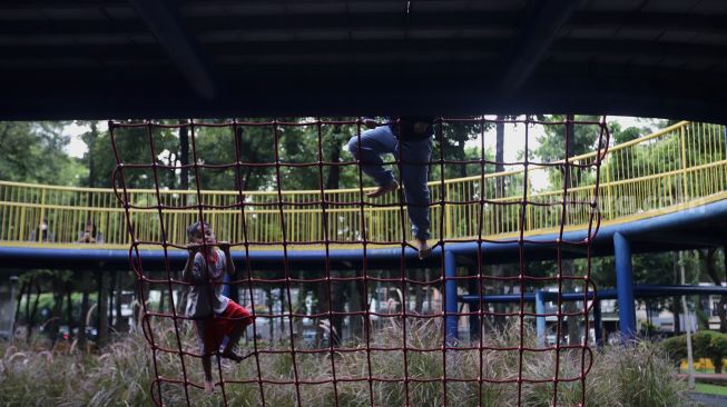 Dua orang anak bermain di Taman Puring, Jakarta, Rabu (20/4/2022). [Suara.com/Angga Budhiyanto]