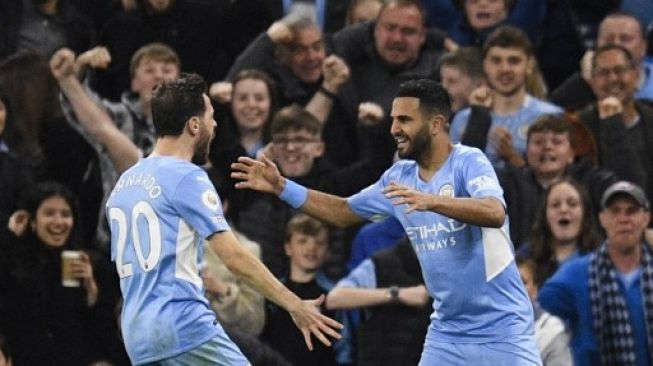 Gelandang Manchester City Riyad Mahrez (kanan) merayakan golnya pada pertandingan sepak bola Liga Premier Inggris antara Manchester City dan Brighton and Hove Albion di Stadion Etihad di Manchester, Inggris, pada 20 April 2022.Oli Scarf / AFP