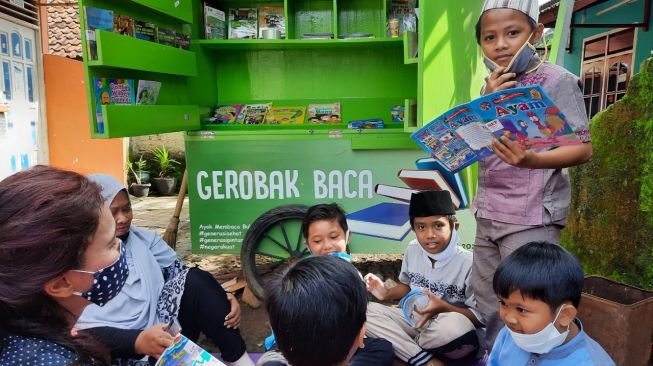 Relawan Maharani membacakan buku untuk anak-anak di Gerobak Baca Maharani di Citayam, Depok. (Dok: Maharani Kirana Pertiwi)