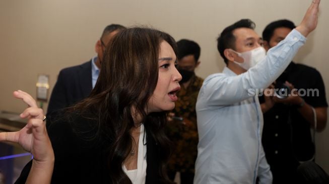 Penyanyi Sri Rossa Roslaina Handiyani atau Rossa menjawab pertanyaan dari awak media usai menjalani pemeriksaan di Bareskrim Polri, Jakarta, Kamis (21/4/2022) malam. [Suara.com/Angga Budhiyanto]