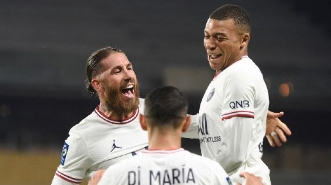 Bek Paris Saint-Germain Sergio Ramos (kiri) merayakan golnya dengan rekan setimnya Kylian Mbappe (kanan) dan Angel Di Maria (tengah) setelah mencetak gol kedua timnya selama pertandingan sepak bola L1 Prancis antara Angers SCO dan Paris Saint-Germain di Stadion Raymond-Kopa di Angers, Prancis pada 20 April 2022. JEAN-FRANCOIS MONIER/AFP