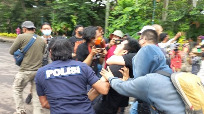 Aparat kepolisian menangkap seorang pria yang diduga sebagai provokator saat aksi unjuk rasa Aliansi Mahasiswa Indonesia (AMI) di kawasan Patung Kuda Jakarta Pusat, Kamis (21/4/2022).