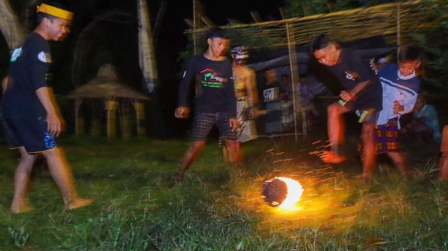 Seorang warga melakukan atraksi api pada acara Purnacandra di Kampung Batara, Papring Kalipuro, Banyuwangi, Jawa Timur, Rabu (20/4/2022) malam.  ANTARA FOTO/Budi Candra Setya