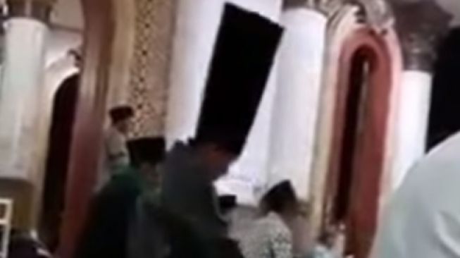 Video Viral Seorang Lelaki Salat Tarawih Memakai Peci Tak Lazim, Ini Fakta di Baliknya