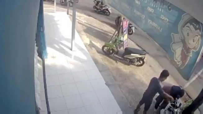 Sejoli pelaku pencurian motor tertangkap kamera CCTV berusaha merusak kunci kontak motor di sebuah tempat laundry di Cipayung, Jaktim. [Tangkapan Layar]