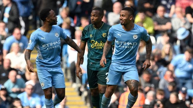 Striker Manchester City asal Brasil, Gabriel Jesus (kanan) melakukan selebrasi dengan Raheem Sterling setelah menciptakan hattricknya dari titik penalti dalam laga pekan ke-34 Liga Inggris antara Manchester City vs Watford di Stadion Etihad, Manchester pada 23 April 2022.Paul ELLIS / AFP.