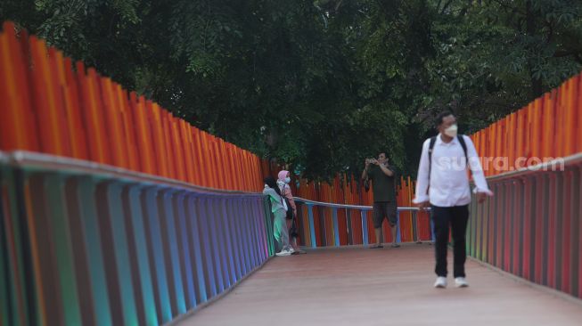 Warga berjalan di Tebet Eco Park, Jakarta, Sabtu (23/4/2022). [Suara.com/Angga Budhiyanto]