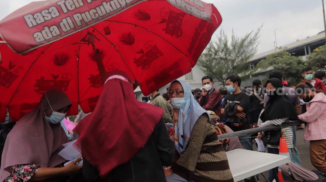 Warga mengantre untuk mendaftar mudik gratis angkutan Lebaran di Polda Metro Jaya, Jakarta, Sabtu (23/4/2022). [Suara.com/Angga Budhiyanto] 