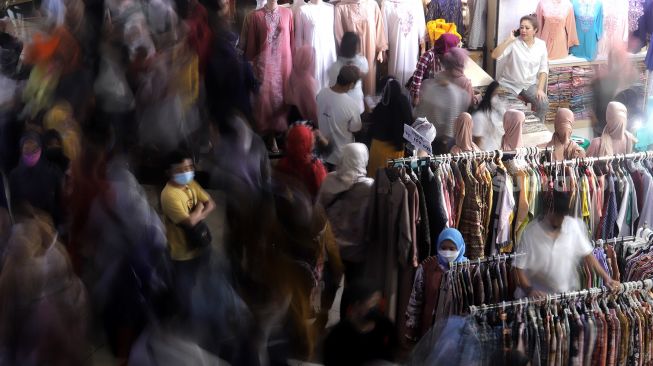 Pengunjung melihat pakaian di Pasar Tanah Abang, Jakarta, Sabtu (23/4/2022). [Suara.com/Angga Budhiyanto]