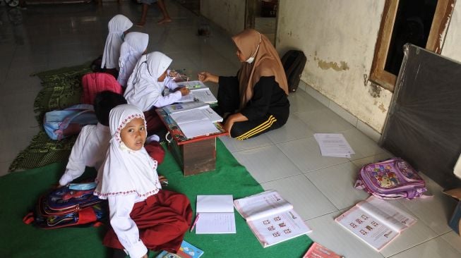 Guru SDN Jugosari 03 Eri Eliyawati mengajar sejumlah murid di rumah warga di Dusun Sumberlangsep, Desa Jugosari, Candipuro, Lumajang, Jawa Timur.