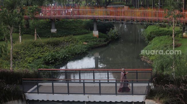 Warga berjalan di Tebet Eco Park, Jakarta, Sabtu (23/4/2022). [Suara.com/Angga Budhiyanto]