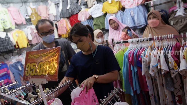 Pengunjung memilih pakaian di Pasar Tanah Abang, Jakarta, Sabtu (23/4/2022). [Suara.com/Angga Budhiyanto]