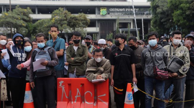 Warga mengantre untuk mendaftar mudik gratis angkutan Lebaran di Polda Metro Jaya, Jakarta, Sabtu (23/4/2022). [Suara.com/Angga Budhiyanto] 